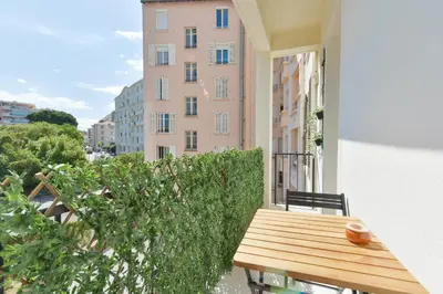 a balcony with a wooden table and a building at Rare luxury 3-Br near the Croisette in Cannes