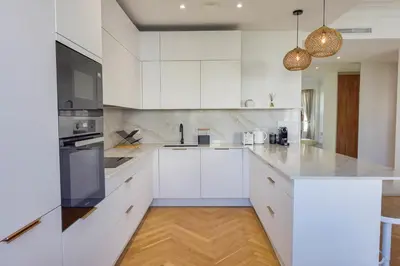 a white kitchen with white cabinets and appliances at Rare luxury 3-Br near the Croisette in Cannes