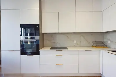a white kitchen with white cabinets and an oven at Rare luxury 3-Br near the Croisette in Cannes