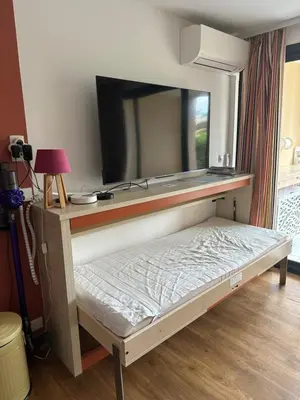 a bed in a room with a flat screen tv at Villa Francia Résidence piscine tennis à 500m des plages de Cannes in Cannes