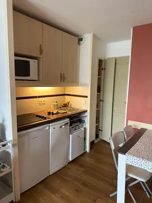 a kitchen with white appliances and a table with chairs at Villa Francia Résidence piscine tennis à 500m des plages de Cannes in Cannes