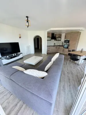 a living room with a gray couch and a table at Appartement vue mer, Long Beach in Cannes