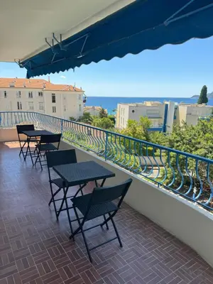 a balcony with tables and chairs and the ocean at Appartement vue mer, Long Beach in Cannes