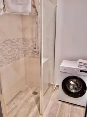 a washing machine in a bathroom with a shower at Appartement vue mer, Long Beach in Cannes