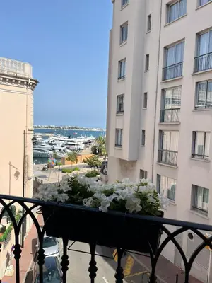 a balcony with a planter with white flowers on it at Apartments in the old town in Cannes