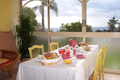 a white table with food on it in front of a window at Maison Louijane in Vallauris