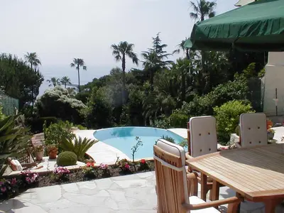 a table and chairs next to a swimming pool at Maison Louijane in Vallauris