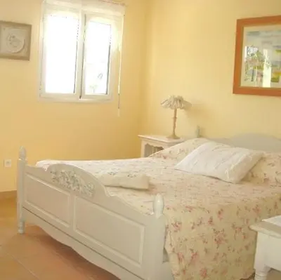a white bed in a bedroom with a window at Maison Louijane in Vallauris