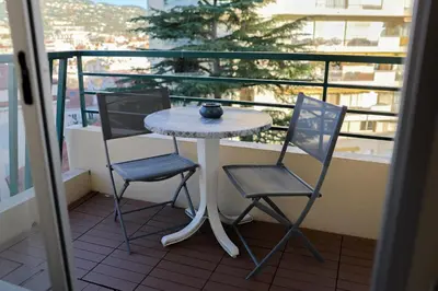 a table and two chairs on a balcony at Appartement à 10min à pied Palais Festivals in Cannes