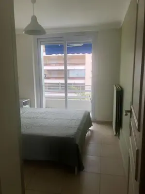 a bedroom with a bed and a large window at Appartement 3 pièce à Cannes in Cannes