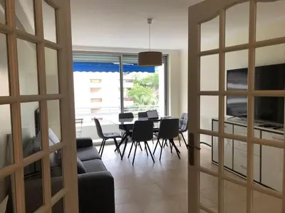 a living room with a couch and a table and chairs at Appartement 3 pièce à Cannes in Cannes