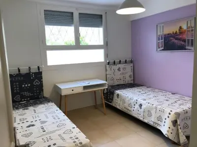 a bedroom with two beds and a desk and a window at Appartement 3 pièce à Cannes in Cannes