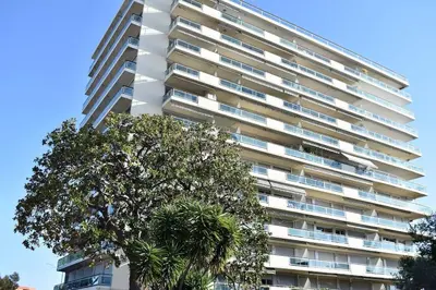 a tall building with a tree in front of it at Studio bord de mer in Cannes