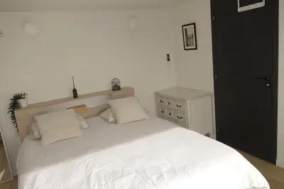 a bedroom with a large white bed and a dresser at Studio Toit terrasse - Vue mer Cannes in Le Cannet