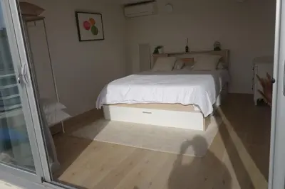 a bedroom with a white bed and a glass door at Studio Toit terrasse - Vue mer Cannes in Le Cannet