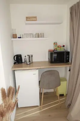 a kitchen with a desk and a chair and a microwave at Studio Toit terrasse - Vue mer Cannes in Le Cannet
