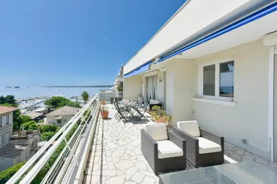 a balcony with chairs and a view of the ocean at Cozy top-floor 2-Br apartment terrace and sea view in Cannes