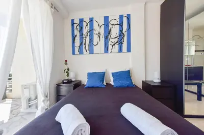 a bedroom with a large bed with blue pillows at Cozy top-floor 2-Br apartment terrace and sea view in Cannes