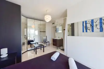 a room with a bed and a living room at Cozy top-floor 2-Br apartment terrace and sea view in Cannes