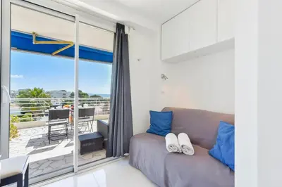 a living room with a couch and a balcony at Cozy top-floor 2-Br apartment terrace and sea view in Cannes