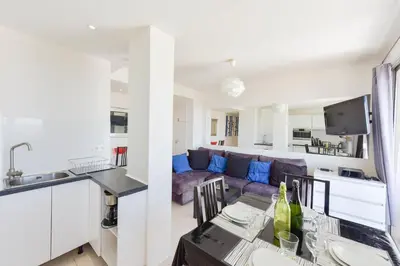 a kitchen and living room with a couch and a table at Cozy top-floor 2-Br apartment terrace and sea view in Cannes