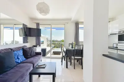 a living room and dining room with a couch and a table at Cozy top-floor 2-Br apartment terrace and sea view in Cannes