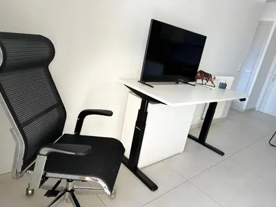 a computer desk with a monitor and a chair at Super Apartment, Parking, Terrace, Lift, WIFI, Palm Beach, Cannes in Cannes