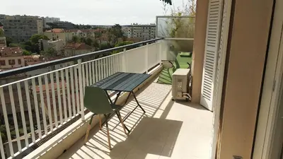 a balcony with a table and a view of a city at Beau 2 pièces centre de Cannes idéal congres et vacances in Cannes
