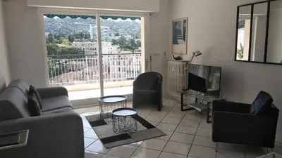 a living room with a couch and a television at Beau 2 pièces centre de Cannes idéal congres et vacances in Cannes