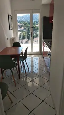 a dining room with a table and chairs and a kitchen at Beau 2 pièces centre de Cannes idéal congres et vacances in Cannes