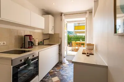 a kitchen with white cabinets and a counter top at maison de ville La Fontaine BAu4 in Le Cannet
