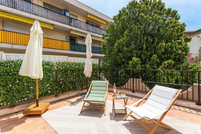 a patio with two chairs and an umbrella and a table at maison de ville La Fontaine BAu4 in Le Cannet