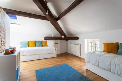 a bedroom with two beds and a blue rug at maison de ville La Fontaine BAu4 in Le Cannet