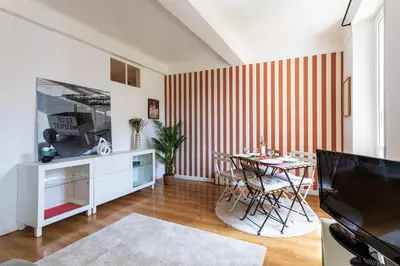 a living room with a table and a striped wall at maison de ville La Fontaine BAu4 in Le Cannet