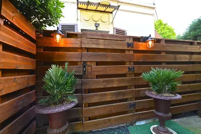 a wooden fence with two potted plants on it at Cité Saint Paul Terrasse Parking Clim Wifi Sauna in Cannes