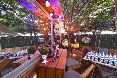 a restaurant with tables and chairs and trees and lights at Cité Saint Paul Terrasse Parking Clim Wifi Sauna in Cannes