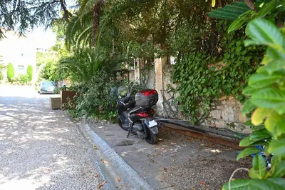 a motorcycle parked on a sidewalk next to a building at Cité Saint Paul Terrasse Parking Clim Wifi Sauna in Cannes