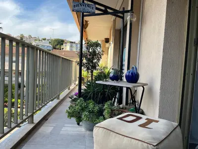 a balcony with a ottoman sitting on a porch at Chambre cosy dans T3 in Cannes