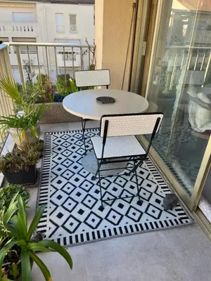 a patio with a table and chairs on a balcony at Chambre cosy dans T3 in Cannes