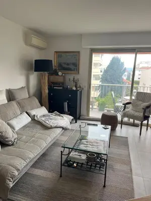 a living room with a couch and a glass table at Chambre cosy dans T3 in Cannes