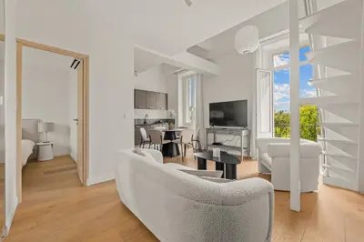a living room with a couch and a table at LB Vacation Rentals I Beautiful, Renovated Duplex with Swimming Pool in Cannes