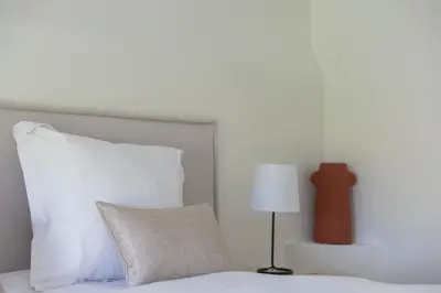 a bed with a white pillow and a lamp at LB Vacation Rentals I Beautiful, Renovated Duplex with Swimming Pool in Cannes
