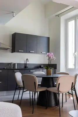 a kitchen with a black table and chairs at LB Vacation Rentals I Beautiful, Renovated Duplex with Swimming Pool in Cannes