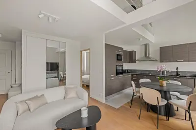 a living room and kitchen with a couch and tables at LB Vacation Rentals I Beautiful, Renovated Duplex with Swimming Pool in Cannes