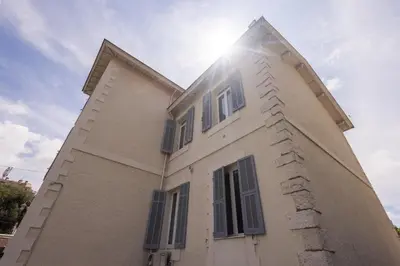 a white house with the sun shining on it at LB Vacation Rentals I Beautiful, Renovated Duplex with Swimming Pool in Cannes