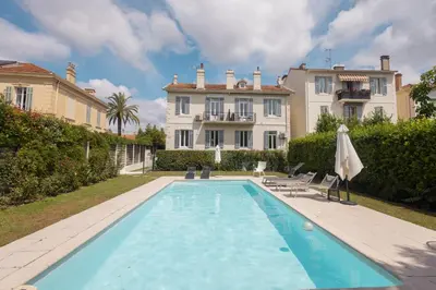 a large swimming pool in front of a house at LB Vacation Rentals I Beautiful, Renovated Duplex with Swimming Pool in Cannes