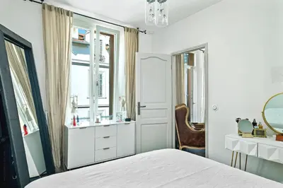 a bedroom with a bed and a mirror and a chair at Immogroom - T4 - Center - 8 min from Palais in Cannes