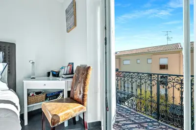 a bedroom with a bed and a desk on a balcony at Immogroom - T4 - Center - 8 min from Palais in Cannes