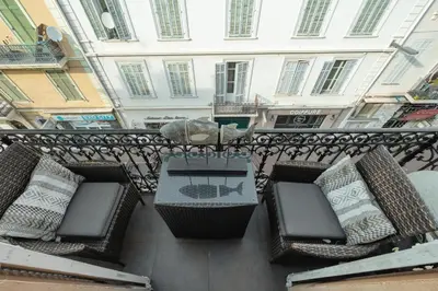 a table and chairs on a balcony with a building at Immogroom - T4 - Center - 8 min from Palais in Cannes