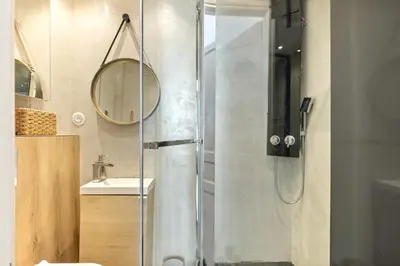 a bathroom with a shower with a sink and a mirror at Immogroom - T4 - Center - 8 min from Palais in Cannes